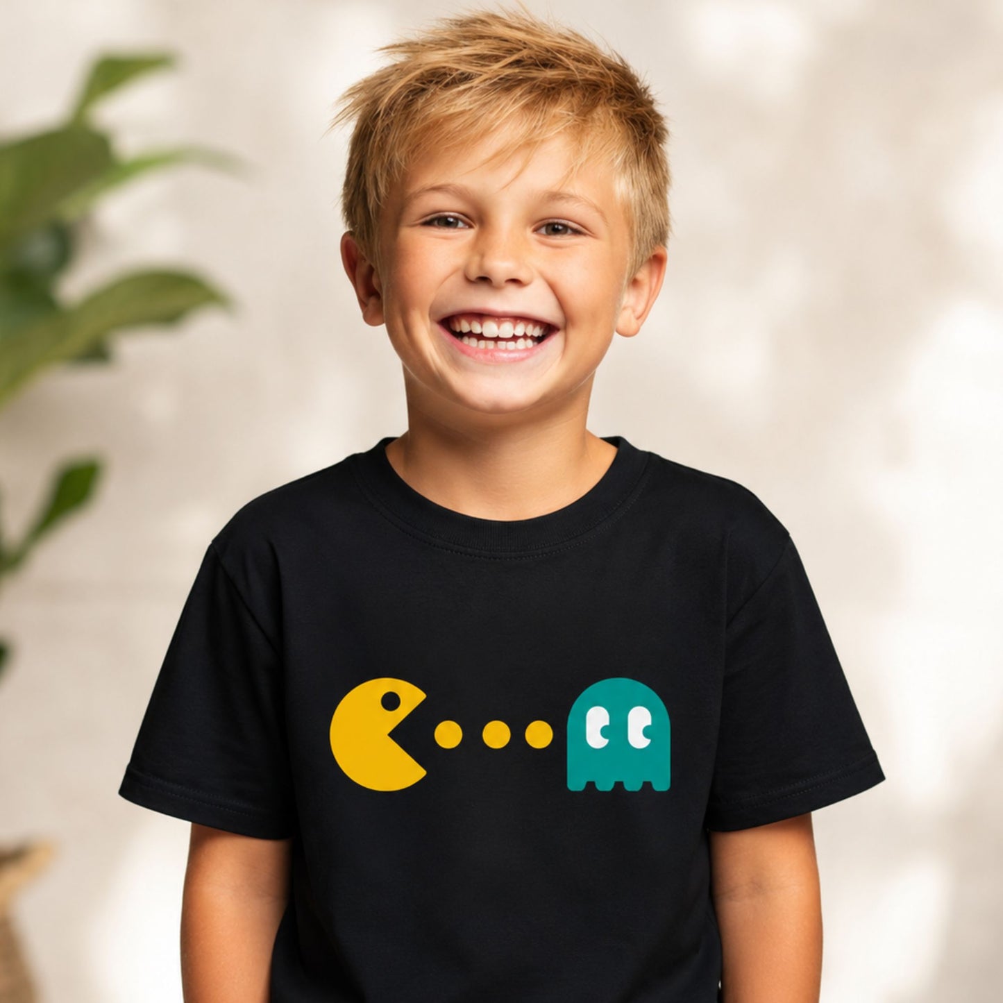 Child wearing a black t-shirt with Pac-Man and ghost logo