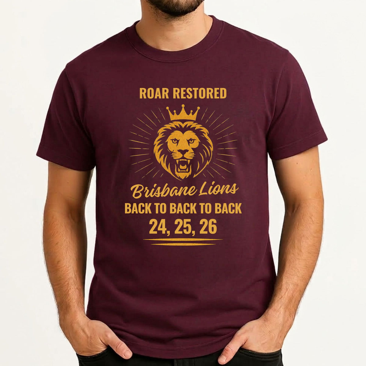 A man wearing a maroon short-sleeve t-shirt with a gold graphic print of a lion and the text 'ROAR RESTORED Brisbane Lions BACK TO BACK TO BACK 24, 25, 26'.