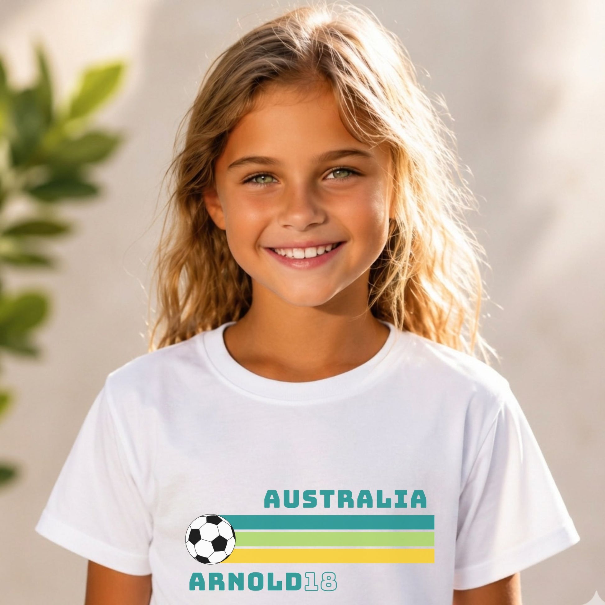Young girl wearing a white Matildas t-shirt with 'Australia' and Arnold 16 and a soccer ball design.