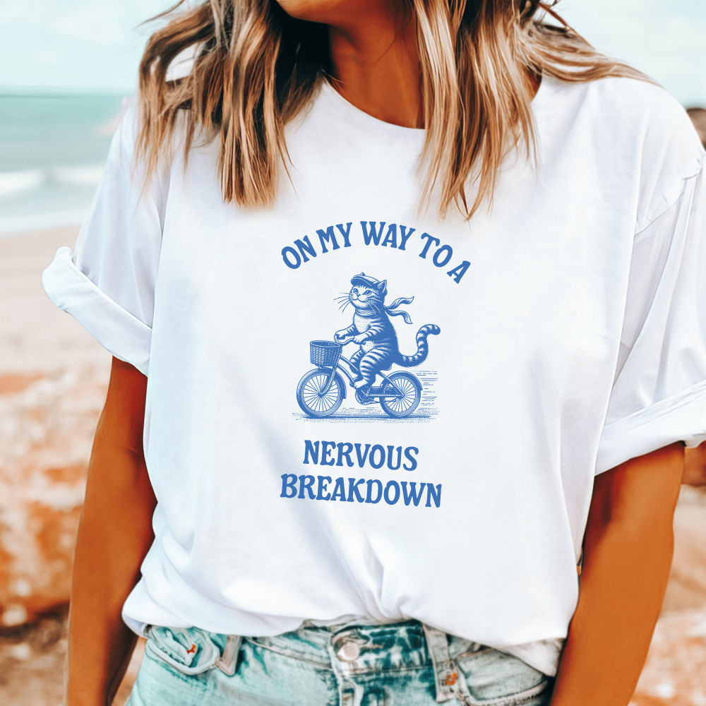 Funny 'On my way to a nervous breakdown' t-shirt, cartoon cat on a bike, perfect for mental health awareness and humor lovers